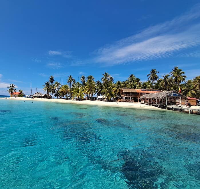 Relaxing view of San Blas Islands with turquoise waters and palm trees from Panama City tour.